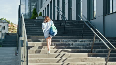 woman walking up stairs in front of modern building