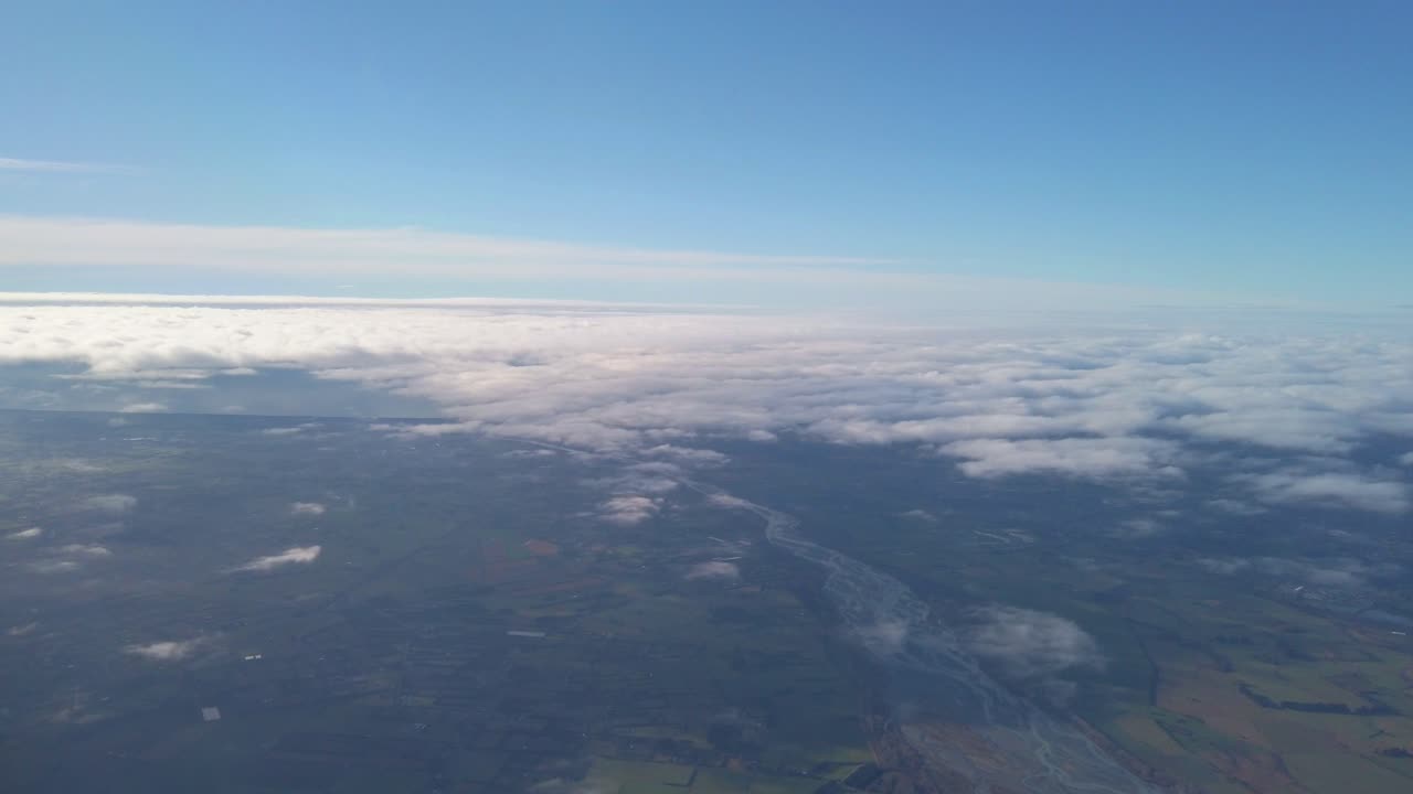 Aerial shot over a river surrounded by farmland