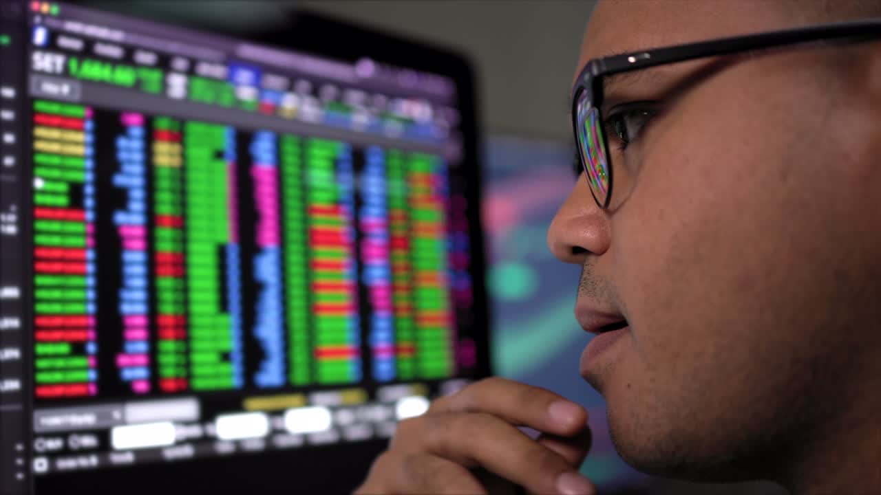 Investor businessman analyzing a graphic of a stock, cryptocurrency exchange chart and looks at computer monitor. Financial analyst working with real-time exchange rate diagram. Investment concept