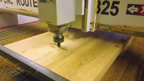 la máquina enrutadora cnc comienza el proceso de fresado en bruto en una tabla de madera de roble