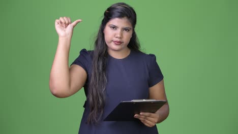 joven sobrepeso hermosa mujer de negocios india contra fondo verde