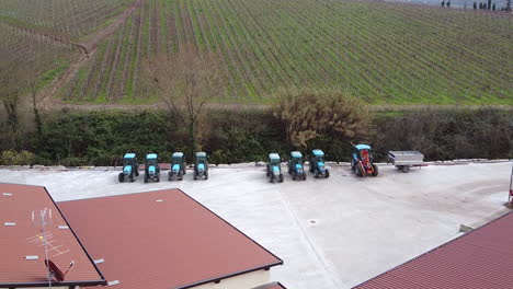 wine farm with tractors and vineyards in tuscany italy, aerial