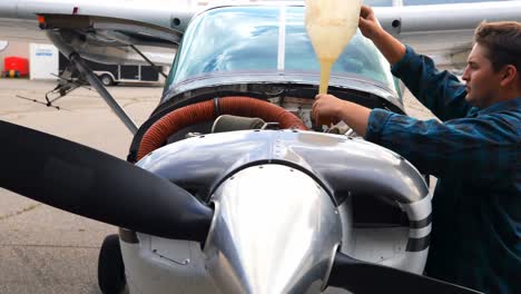 engineer filling oil in aircraft engine 4k