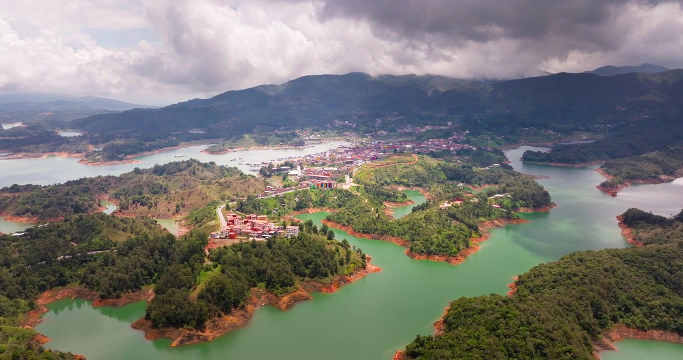 Cảnh quay drone thị trấn nằm trên hồ chứa rộng lớn ở Guatape, Colombia. Tiến về phía trước từ trên không