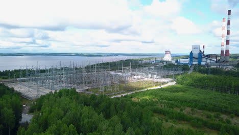 aerial view of power plant and substation near a river