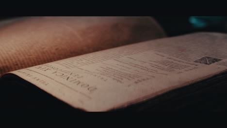 an someone turn pages of an old book inside the sailing ship cabin
