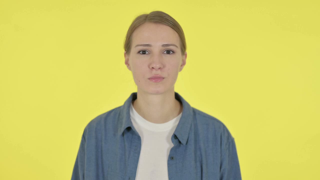 Rejecting  Woman Shaking Head in Denial on Yellow Background