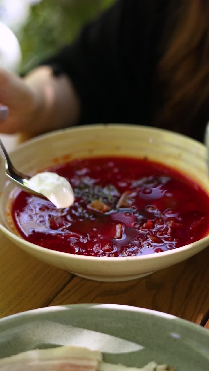 una mujer comiendo sopa de borscht.