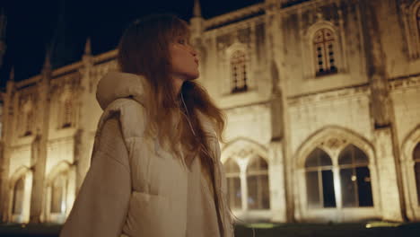 pensive tourist walking historic building at night closeup. woman contemplating