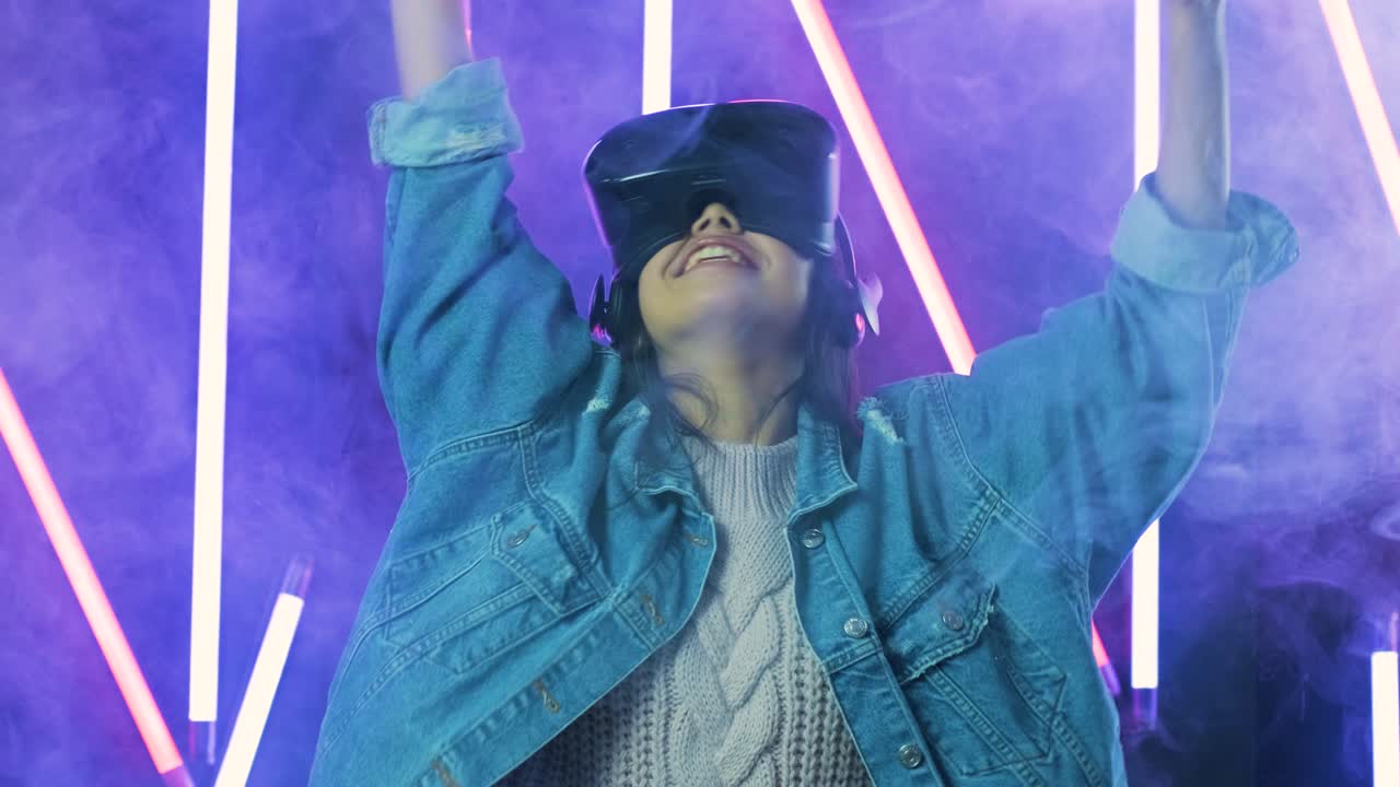 giovane donna con le cuffie vr si guarda intorno e si chiede quanto sia sorprendente. casco di realtà virtuale su sfondo di luce a colori fumo