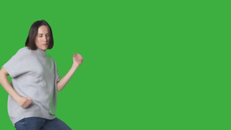 mujer emocionada bailando y caminando sobre la pantalla verde