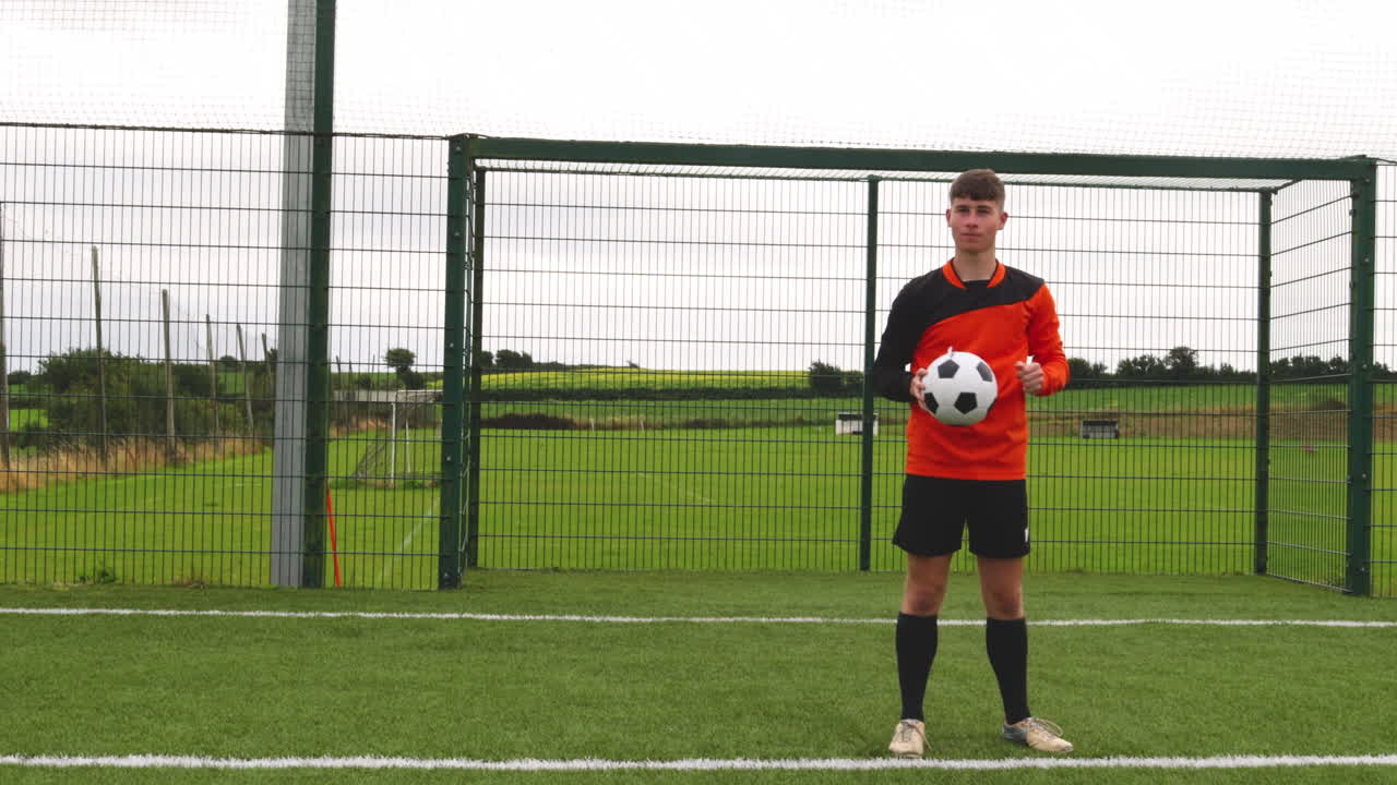 Soccer player preparing to throw ball during outdoor practice on field