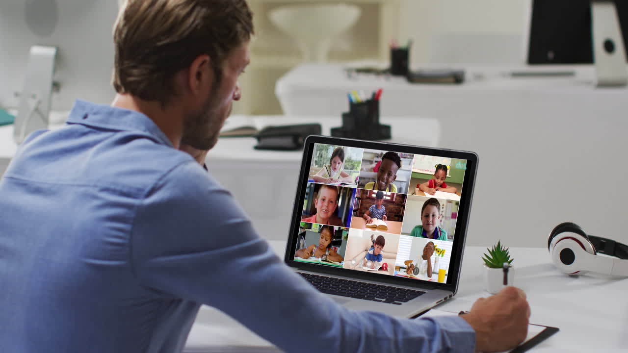 Caucasian male teacher using laptop on video call with school children