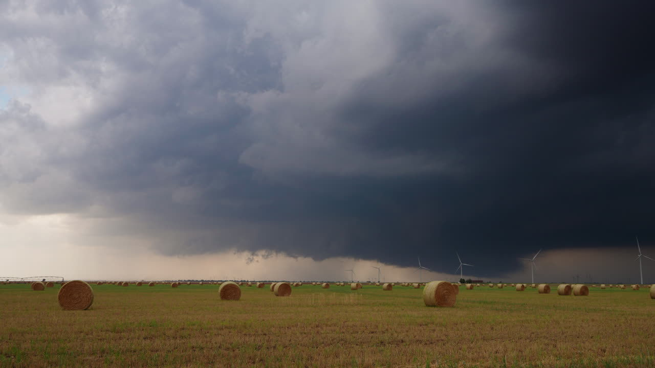 Stormskyer driver langsomt hen over landbrugsjord og vindmøller