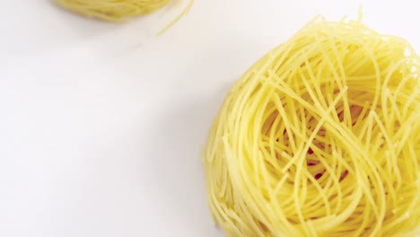 Three-roll-of-uncooked-spaghetti-on-white-background