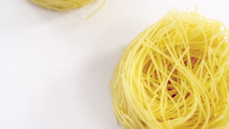 tres rollos de espagueti crudo sobre un fondo blanco