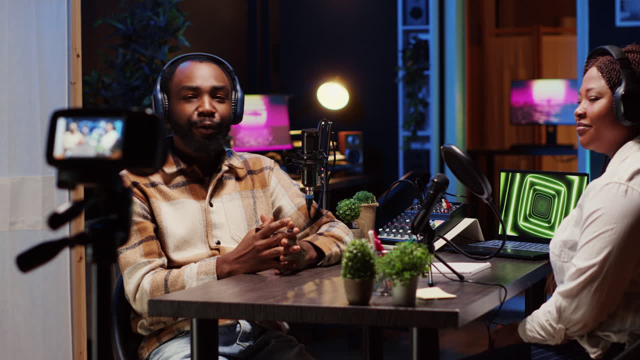 Podcast presenter having live discussion with woman, streaming it for audience