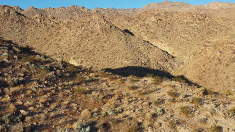 el dron se eleva lentamente y luego se mueve hacia adelante rápidamente sobre la cresta de una montaña árida.