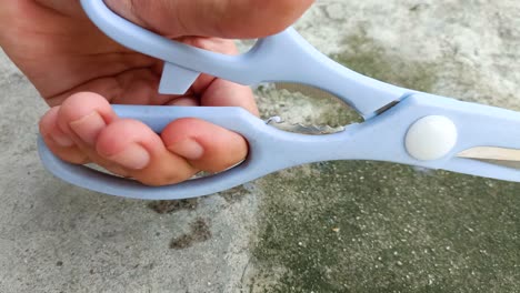 close up of hand holding scissors