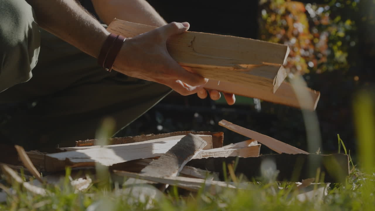 A man picks up wooden logs