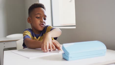 video of focused african american boy doing lessons in classroom