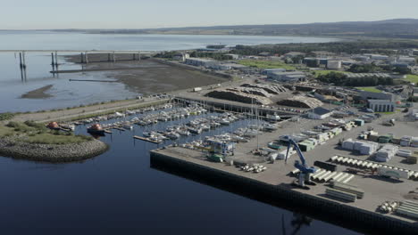 Eine-Luftaufnahme-Des-Hafens-Von-Inverness-Mit-Der-Kessock-Brücke-Im-Hintergrund-An-Einem-Sonnigen-Sommermorgen