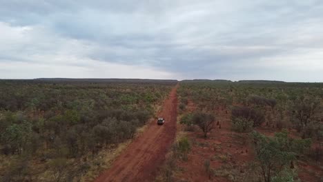 Aerial-Shot-of-Driving-Along-a-Red-Dirt-Road-in-a-Vast,-Empty,-Outback-Landscape