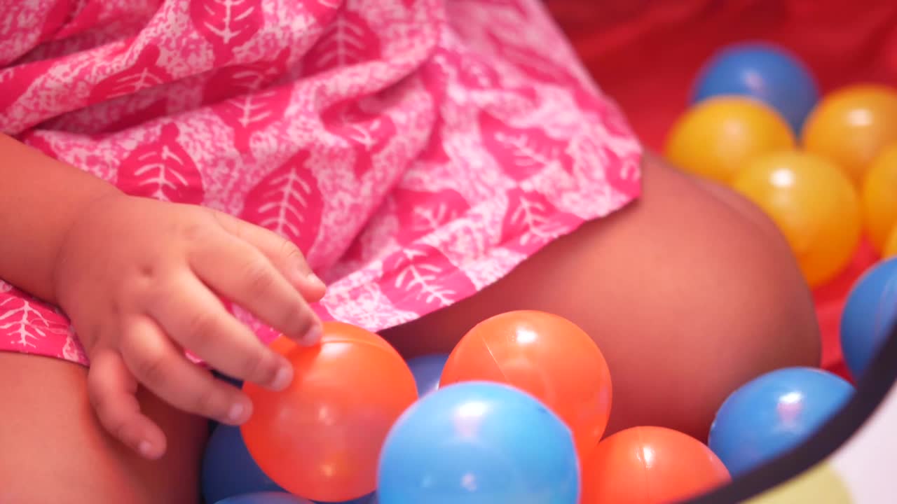 niño pequeño jugando en un pozo de pelota