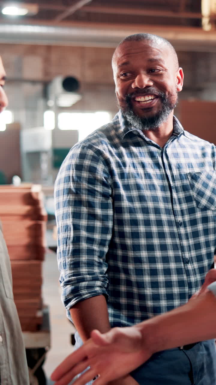 Uomo sorridente che stringe la mano in un'officina industriale