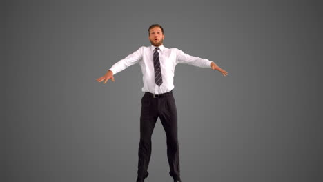 businessman jumping and stretching towards the camera on grey background