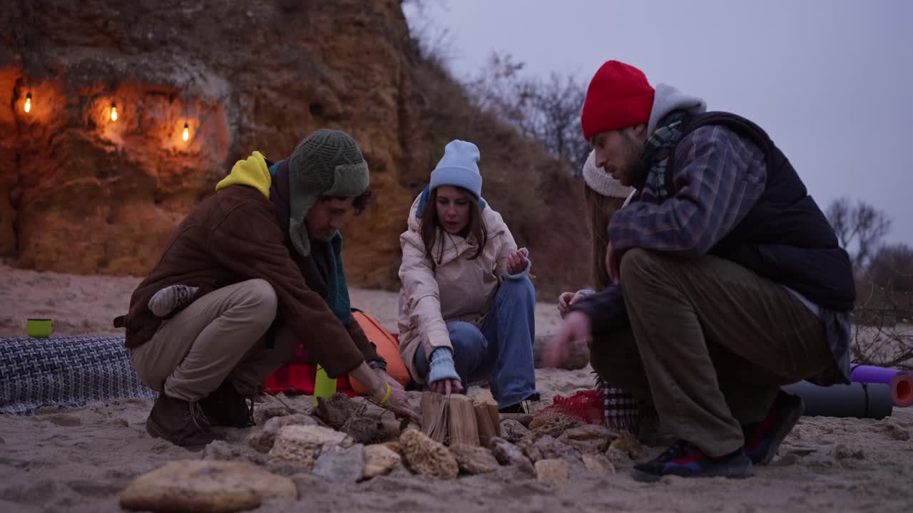 Friends enjoying a campfire on the beach in winter
