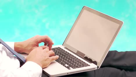 hombre de negocios usando una computadora portátil mientras está acostado en una silla de sol