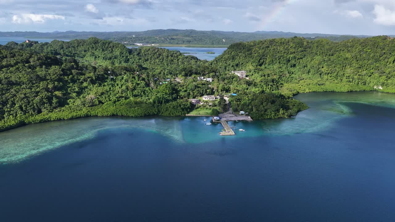 Il filmato di un drone cattura isole verdi lussureggianti e acque turchesi limpide sotto un cielo soleggiato e luminoso.