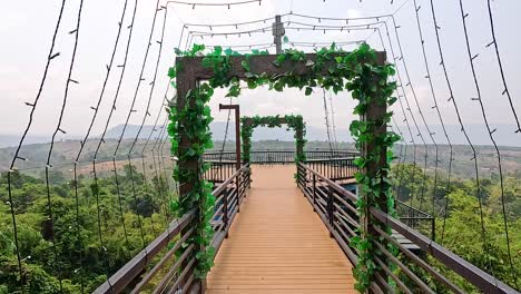 aerial view of a skywalk with lush greenery and expansive vistas in champasak, laos. bright daylight enhances the serene atmosphere