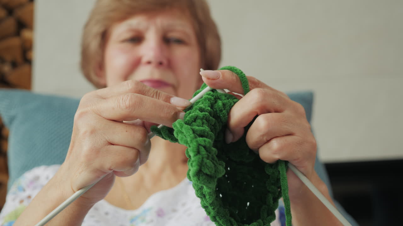 초록색 가닥을 뜨개질 하는 여자
