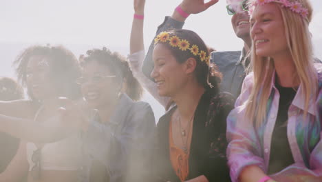 grupo de jóvenes amigos bailando detrás de una barrera en un festival de música al aire libre