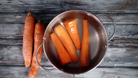 a fall of fresh carrot in a pot of water.