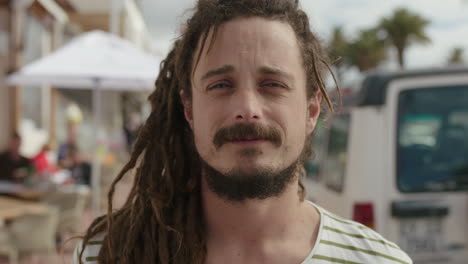 portrait of young friendly man smiling cheerful on busy beachfront background