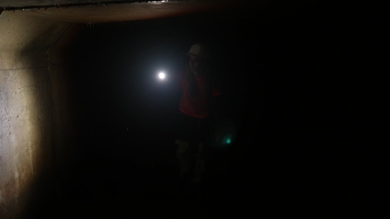 persona con linterna en un túnel oscuro
