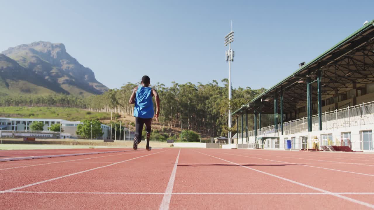 인공 다리를 가진 장애인 혼합 인종 남자가 경주 트랙에서 달리고 있습니다.