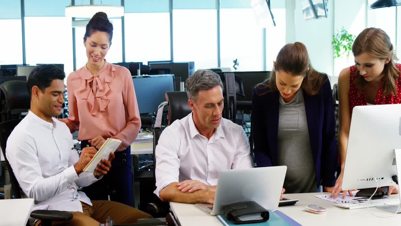 ejecutivos interactuando entre sí en el escritorio en la oficina