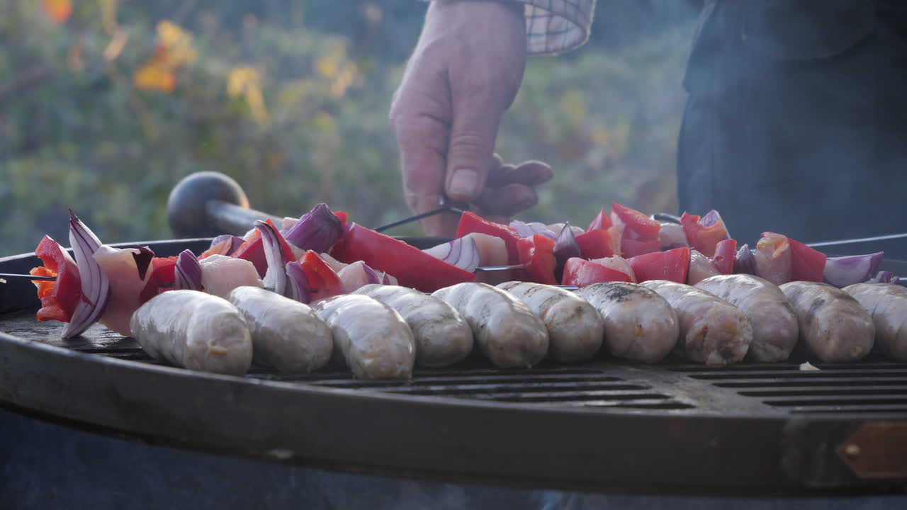 bruschetta and sausages on barbecue with peppers being turned over