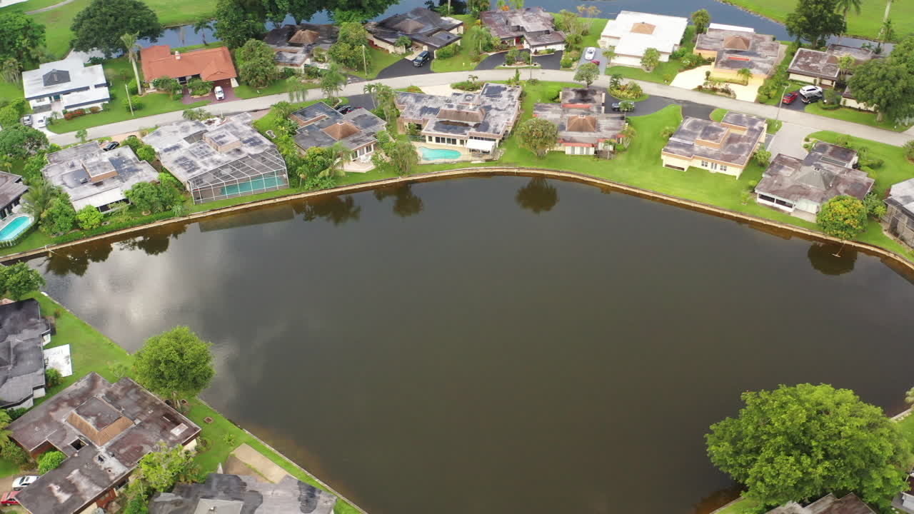 화창한 날 멋진 집과 푸른 잔디로 둘러싸인 반사 연못의 공중 전망