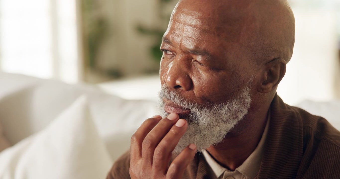 Thoughtful Senior Man Resting Chin on Hand at Home