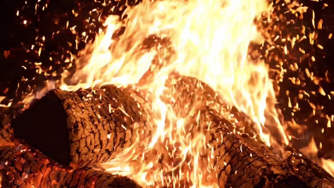 Un spectacle captivant de bois de chauffage brûlant vivement dans un feu de joie intense, créant une atmosphère chaleureuse et invitante avec des flammes dansantes et des braises scintillantes