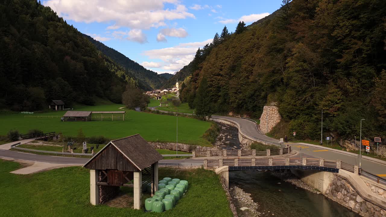 Aerial river ascend establishing Zali Log village and distant mountains with soft daylight over valley