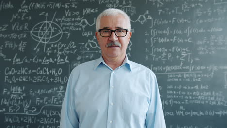 teacher in front of a blackboard full of equations