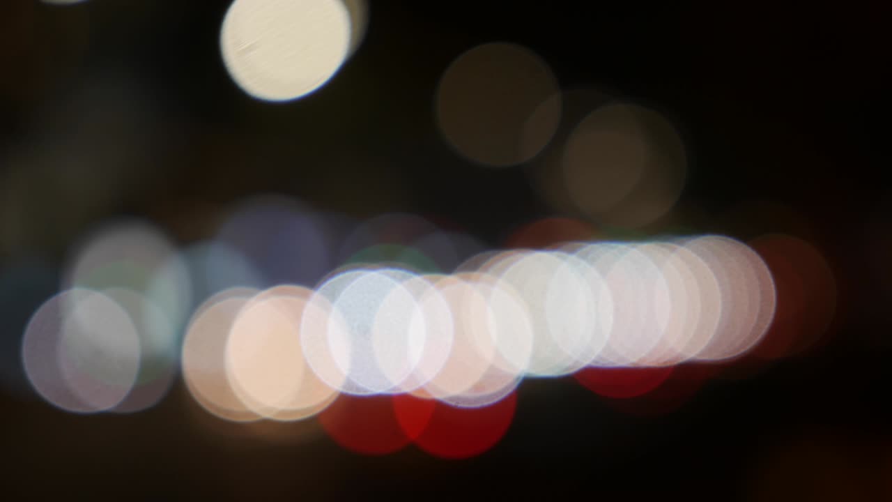 hermoso bokeh brillante en el fondo oscuro borroso por la noche. el redondo bokeh colorido brilla de las luces de los coches en la calle de la ciudad. fuera de foco con borroso. luces de la ciudad sin enfoque. bokeh de tráfico. concepto abstracto