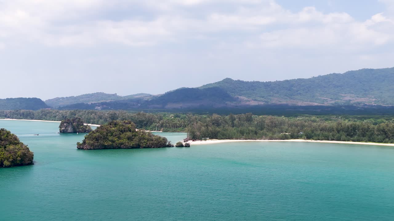 Wide aerial drone shot of turquoise Andaman Sea water and limestone islands under bright daylight