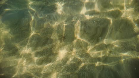 A-close-up-view-of-the-ocean-floor-with-clear-water-and-sunbeams-shining-through